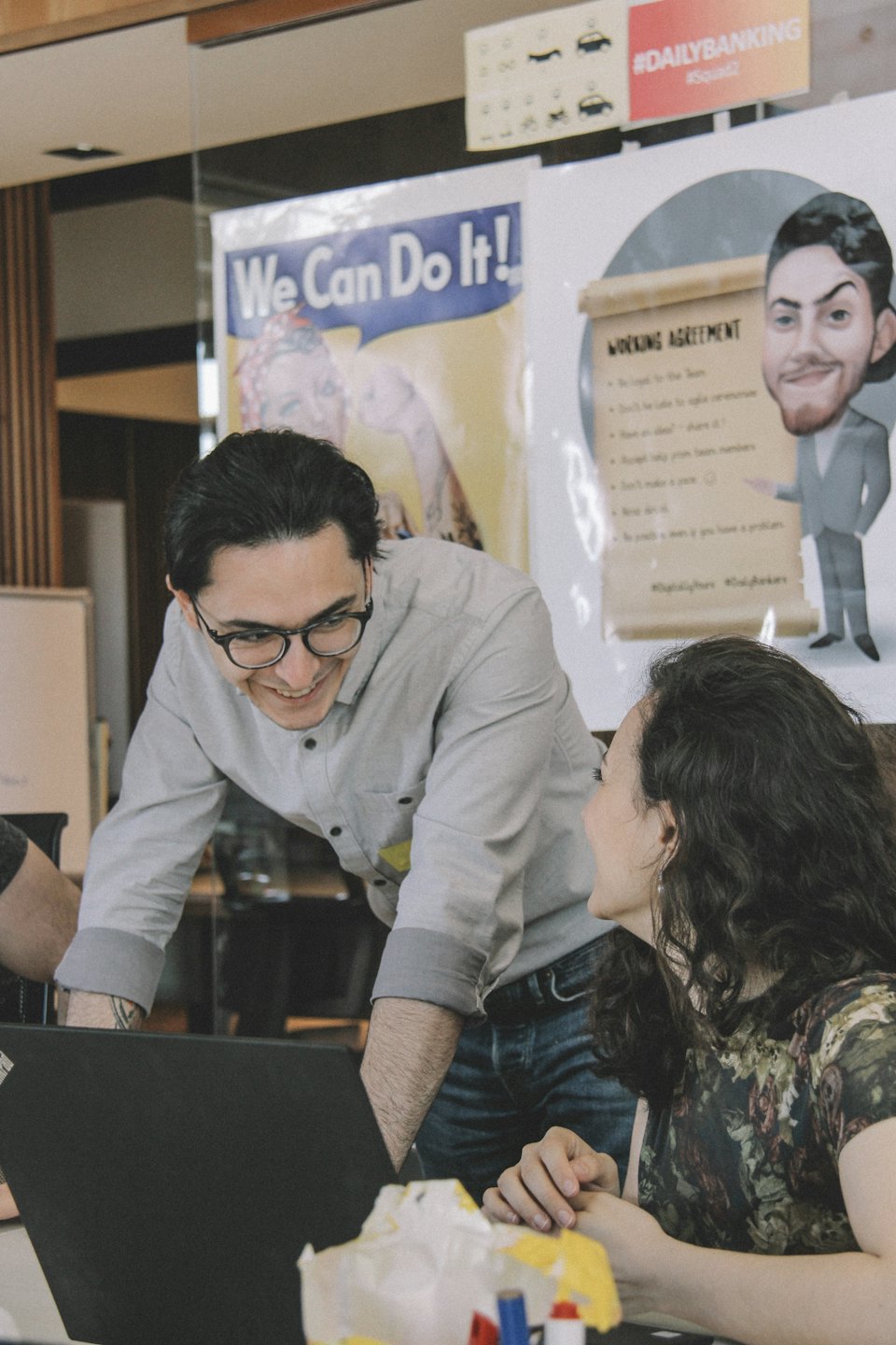 Man and woman collaborate happily at a laptop.